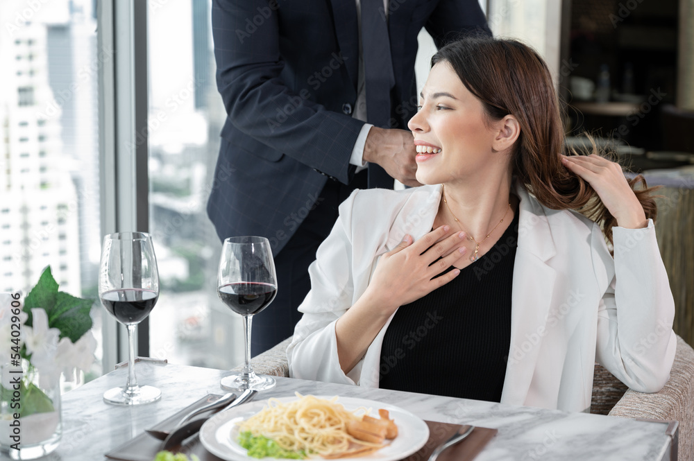 Happy Asia woman getting pearl necklace gift from husband at restaurant hotel with city out of window background