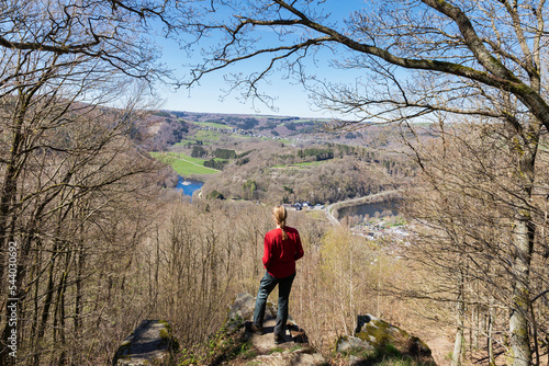 Mature woman standing on rock looking over landscape photo