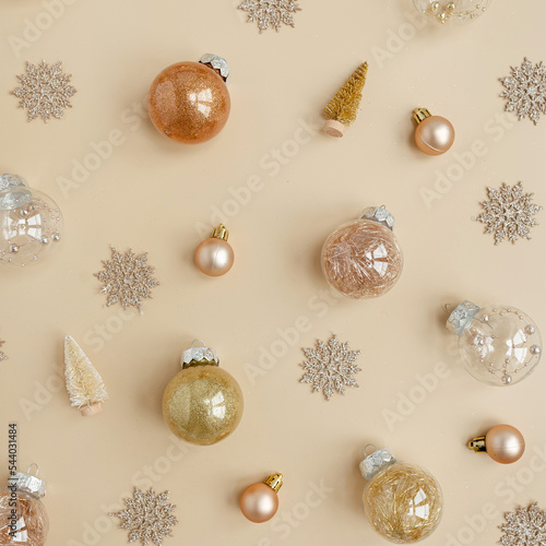 Golden confetti and Christmas toy balls on neutral beige background. Flat lay, top view Christmas holidays background