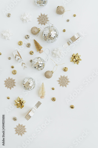 Christmas composition with gold and beige Christmas tree decorations: balls, toy trees, stars. Minimalist New Year, winter holidays card