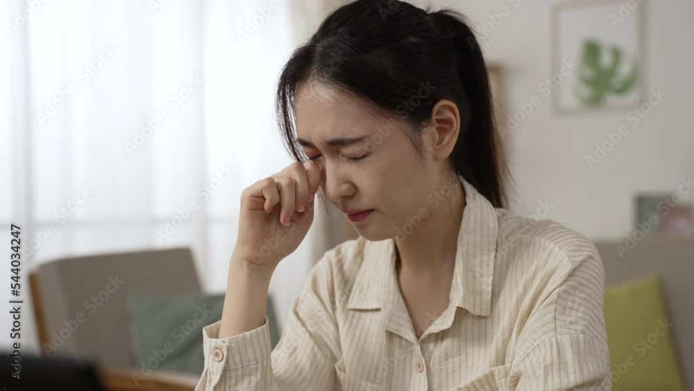 closeup shot of an overworked asian female entrepreneur closing her painful dry eyes with great discomfort while working from home on the laptop closeup shot of an overworked asian female entrepreneur closing her painful dry eyes with great discomfort while working from home on the laptop