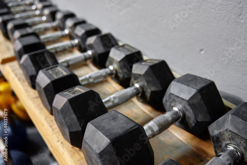 Row of black dumbbells in gym. Equipment for sport exercises. Sport activity and healthy lifestyle concept