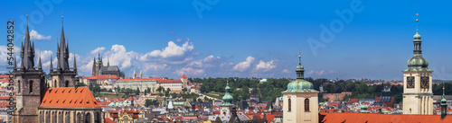 Panorama of Prague city with medieval castle on skyline, old architecture, Cathedrals, gothic towers and spires. Wide landscape of Praga, view on the town with red roofs on houses and top landmarks. photo