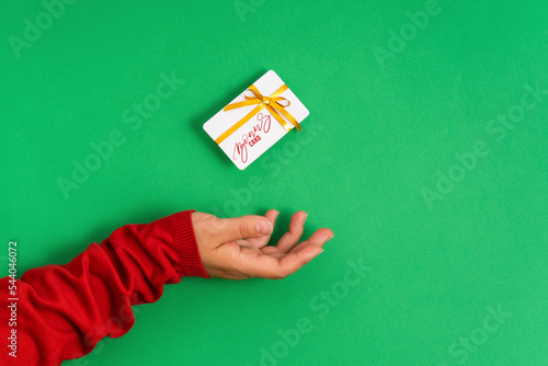Female hand holding levitating bonus card mockup, bank credit card with gift ribbon