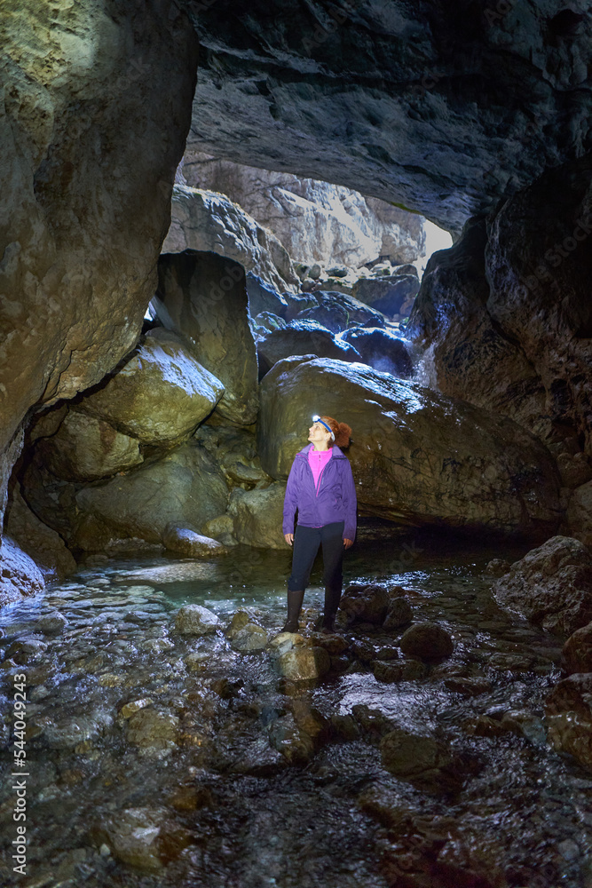 Woman hiking into a cave Woman hiking into a cave