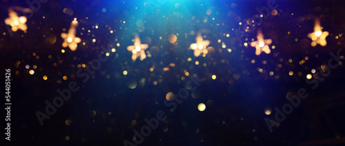 Foto Christmas warm gold garland lights over dark background with glitter overlay