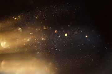 background of abstract glitter lights. gold and black. de focused