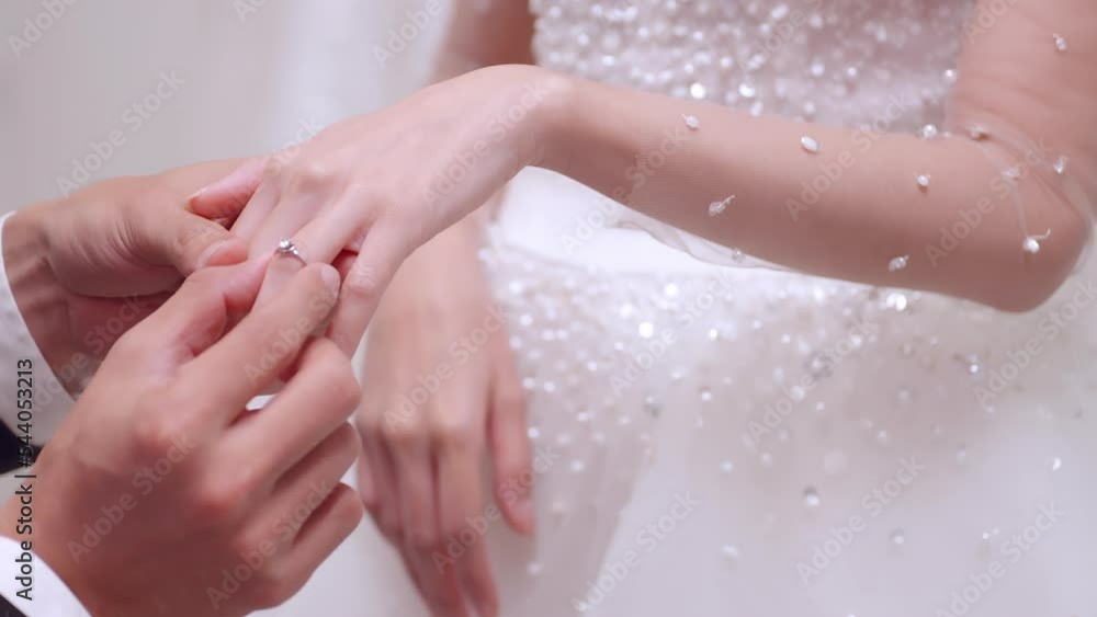 Groom putting wedding ring on finger of bride. Groom putting wedding ring on finger of bride.
