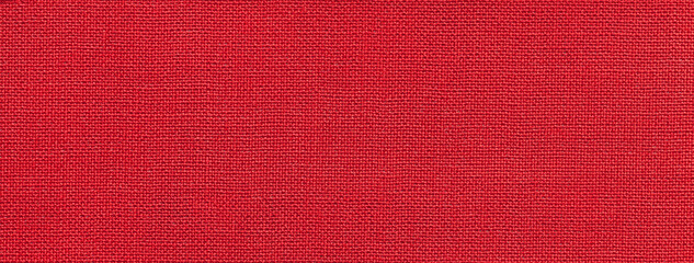 Texture of bright red color background from textile material with wicker pattern. Vintage ruby fabric