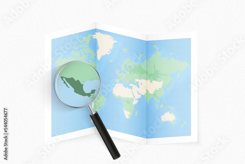 Enlarge Mexico with a magnifying glass on a folded map of the world.