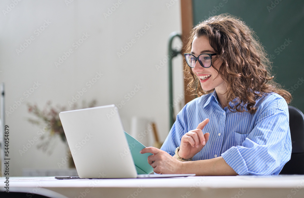 Φωτογραφία Young business woman hr manager coach looking at laptop talking leading hybrid conference online remote video call, virtual work interview meeting or online training presentation working in office