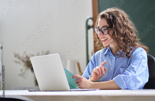 Young business woman hr manager coach looking at laptop talking leading hybrid conference online remote video call, virtual work interview meeting or online training presentation working in office.