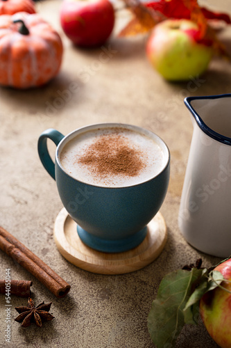 Fototapeta Naklejka Na Ścianę i Meble -  Coffee with milk or latte with cinnamon in blue ceramic cup. Autumn comfort drink.