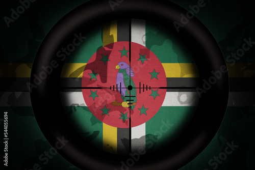 sniper scope aimed at flag of dominica on the khaki texture background. military concept. 3d illustration