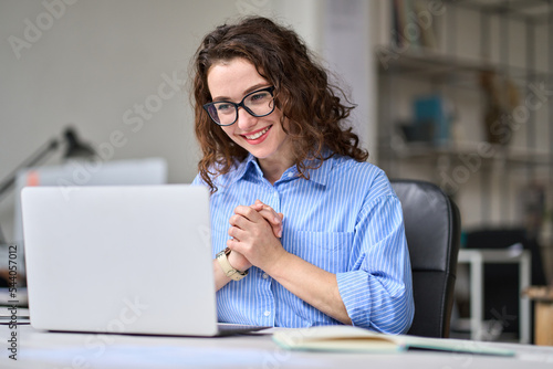 Young happy business woman professional employee feeling excited looking at laptop reading good news online email getting salary growth opportunity, satisfied with good result success at work desk Fototapet
