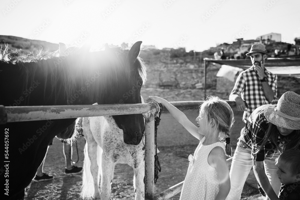 Φωτογραφία Happy family with horse having fun at farm ranch - Focus on little girl hand - B