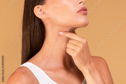 Healthcare, cold and people concept. Closeup of sick lady suffering from sore throat, touching neck with hand