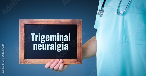 Trigeminal neuralgia. Doctor shows sign/board with wooden frame. Background blue photo