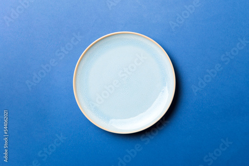 Top view of isolated of colored background empty round blue plate for food. Empty dish with space for your design