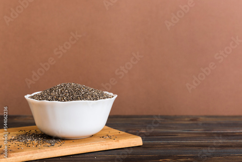 Chia seeds in bowl on colored background. Healthy Salvia hispanica in small bowl. Healthy superfood