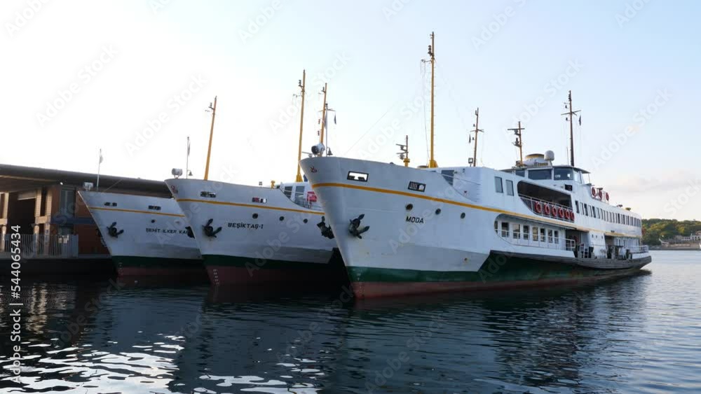 ISTANBUL - AUGUST 08, 2021: Passenger ferries stay ashore in early morning at Karakoy quay. Popular water transport of Istanbul at off-hours. Three similar vessels stay side to side ISTANBUL - AUGUST 08, 2021: Passenger ferries stay ashore in early morning at Karakoy quay. Popular water transport of Istanbul at off-hours. Three similar vessels stay side to side