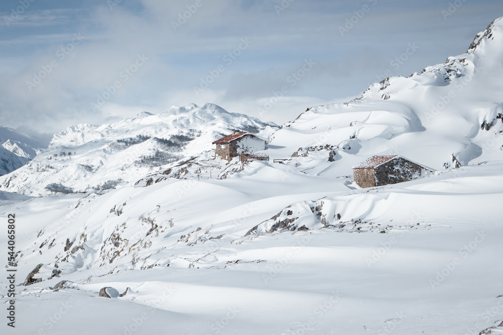 Isolated small house in the middle of huge mountains covered by snow