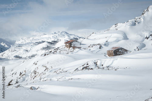 Isolated small house in the middle of huge mountains covered by snow
