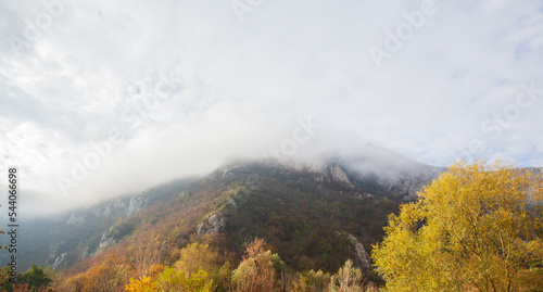 Amazing view of misty mountain peaks in autumn season in the morning. Beautiful nature, fall foggy landscape. 