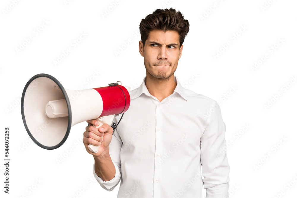 Young caucasian man holding megaphone isolated confused, feels doubtful and unsure. Young caucasian man holding megaphone isolated confused, feels doubtful and unsure.
