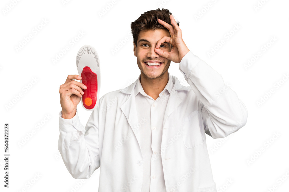 Young caucasian chiropodist man isolated excited keeping ok gesture on eye. Young caucasian chiropodist man isolated excited keeping ok gesture on eye.