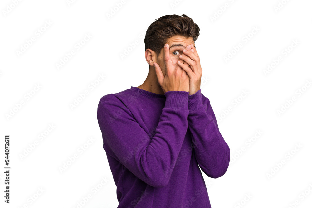 Young caucasian handsome man isolated blink through fingers frightened and nervous. Young caucasian handsome man isolated blink through fingers frightened and nervous.