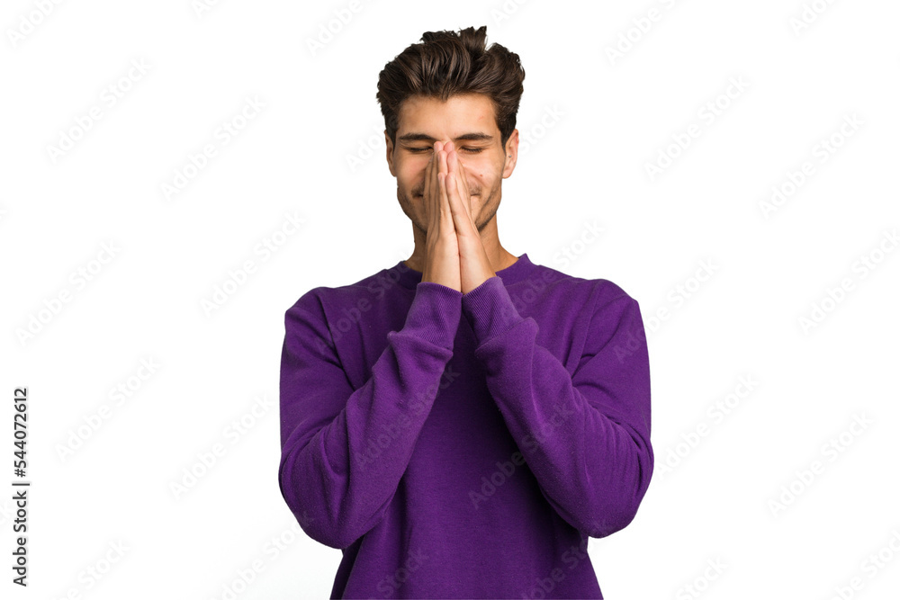 Young caucasian handsome man isolated holding hands in pray near mouth, feels confident. Young caucasian handsome man isolated holding hands in pray near mouth, feels confident.