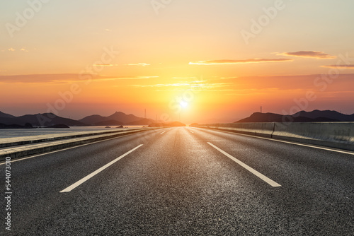 Asphalt road and mountain with beautiful sky clouds at sunset © ABCDstock
