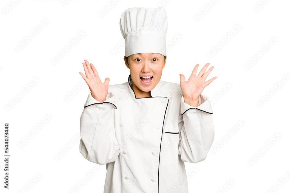 Young asian cook woman isolated receiving a pleasant surprise, excited and raising hands. Young asian cook woman isolated receiving a pleasant surprise, excited and raising hands.