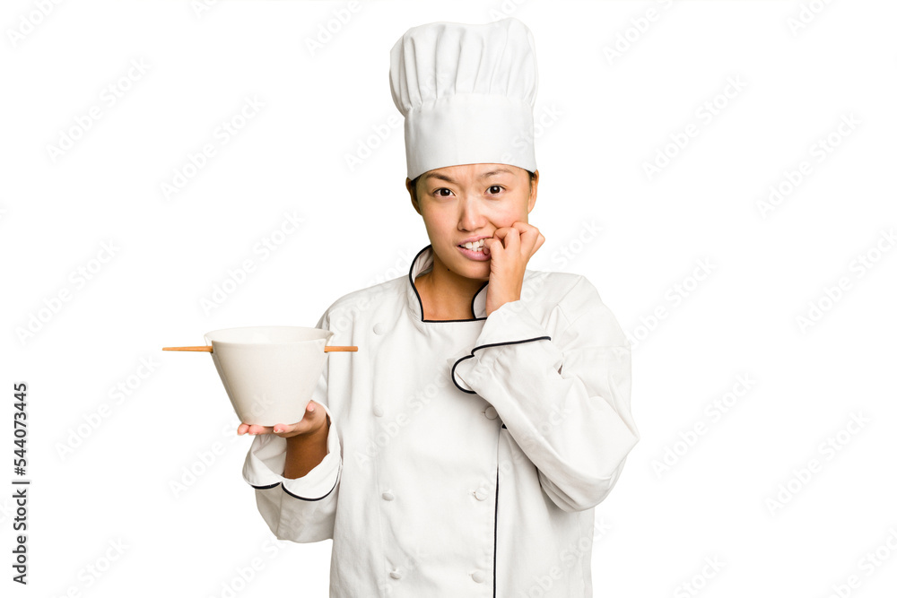 Young chef asian woman holding a bowl of ramen isolated biting fingernails, nervous and very anxious. Young chef asian woman holding a bowl of ramen isolated biting fingernails, nervous and very anxious.