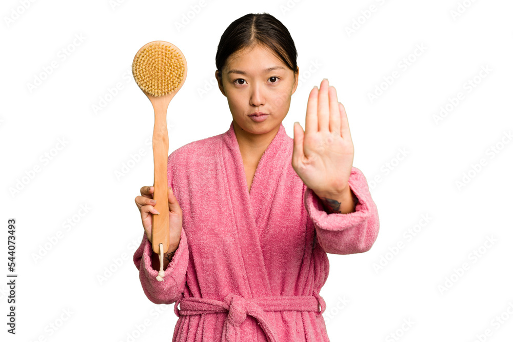 Young asian woman holding a shower brush isolated standing with outstretched hand showing stop sign, preventing you. Young asian woman holding a shower brush isolated standing with outstretched hand showing stop sign, preventing you.