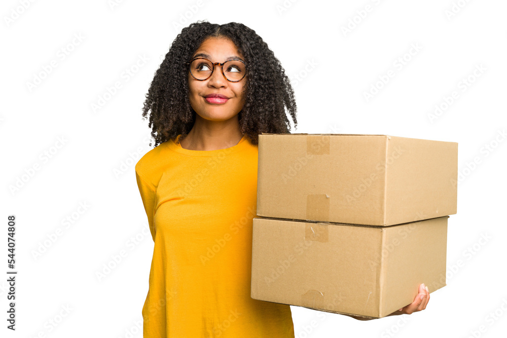 Young african american woman moving to other house while picking up a box full of things isolated dreaming of achieving goals and purposes Young african american woman moving to other house while picking up a box full of things isolated dreaming of achieving goals and purposes