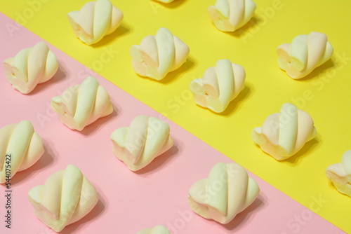 marshmallows in a row on pink and yellow background, close-up