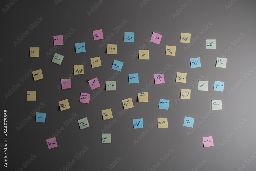 colorful paper notes attached on the wall with reminders in office
