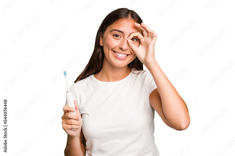 Young caucasian woman holding an electric toothbrush isolated excited keeping ok gesture on eye. Young caucasian woman holding an electric toothbrush isolated excited keeping ok gesture on eye.