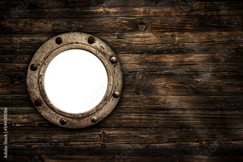 Close-up of an old rusty closed empty porthole window. Old rich wood grain texture background with knots. photo
