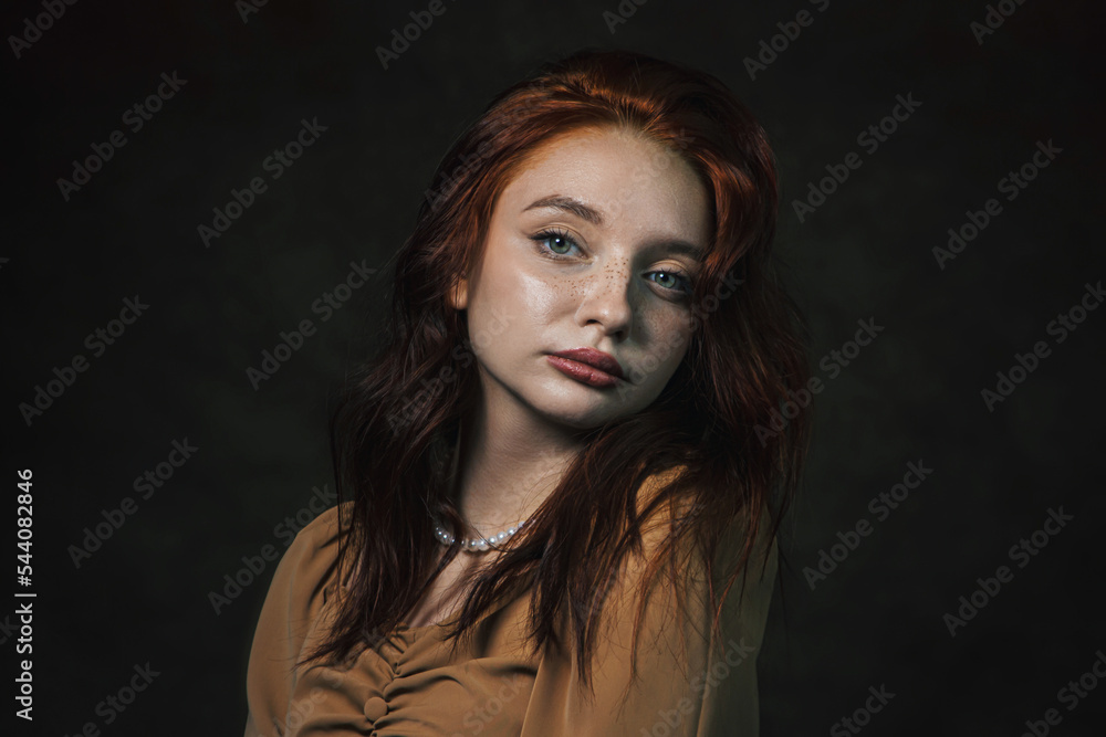 Portrait of a beautiful red-haired girl on a dark background Portrait of a beautiful red-haired girl on a dark background