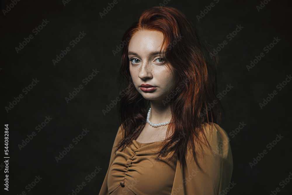 Portrait of a beautiful red-haired girl on a dark background Portrait of a beautiful red-haired girl on a dark background