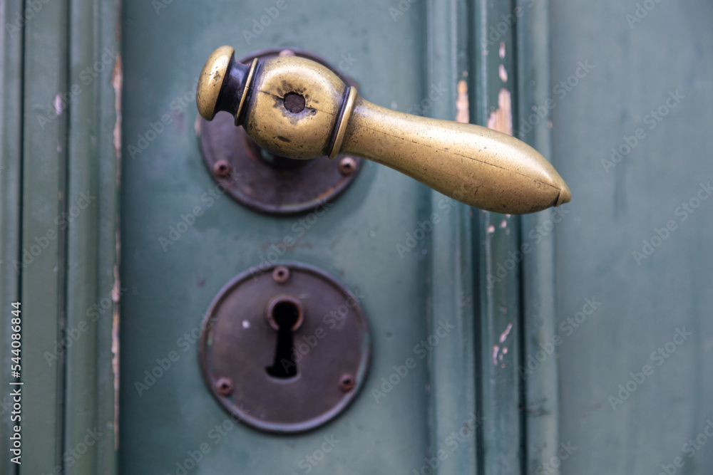 Old metal door knob with a rusty keyhole plate below (focus on the handle) Old metal door knob with a rusty keyhole plate below (focus on the handle)