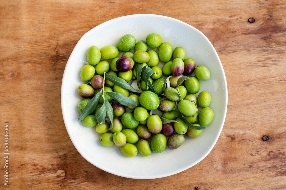 Ripe green olive fruits on a plate. Top view.