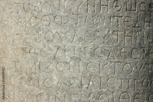 The ancient inscription is on the antique column or the wall. Ancient greek language 