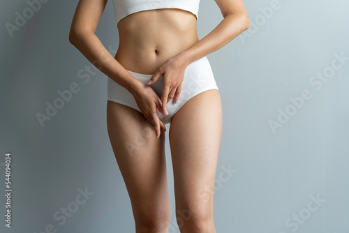 Cropped image of sexy attractive young woman in white underwear showing fit body standing posing hold hand on hips legs isolated on white wall background studio portrait