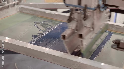 Equipment for serigraphy printing, carousel type - printing on fabric by layers through a stencil, image of different colors. Closeup