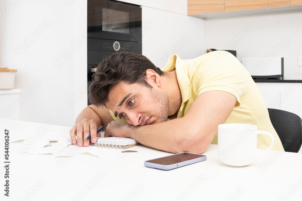 Close up of shocked man sitting at the table, stressed and confused by calculate expense from invoice or bills, have no money to pay mortgage or loan. High prices and spending money concept Close up of shocked man sitting at the table, stressed and confused by calculate expense from invoice or bills, have no money to pay mortgage or loan. High prices and spending money concept