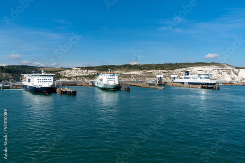 ferries lined up in the ferry terminal of Dover on the English Channel with the White Cliffs of Dover in the background